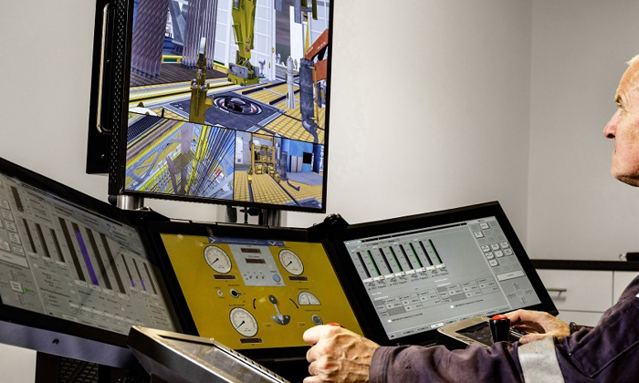 A person using a sophisticated control panel with multiple screens, operating and monitoring various gauges and graphical displays, likely in an industrial or simulation setting.