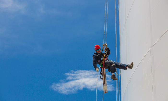 homem a fazer trabalho de acesso por corda numa turbina eólica